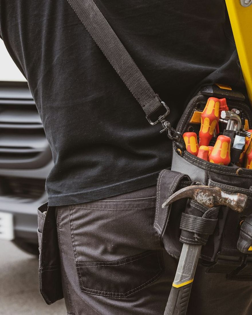 Technician with a tool belt outside a customer's home